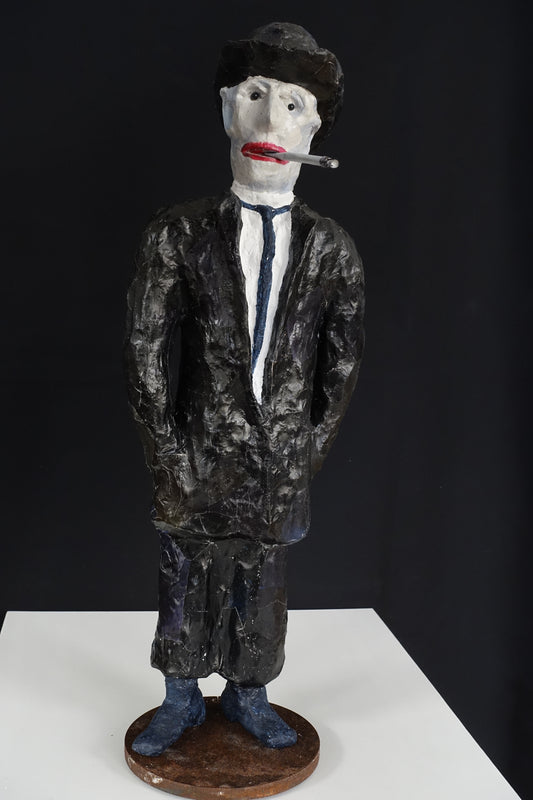 "Raucher mit Bowler-Hut",  figurative Skulptur, angelehnt an die Darstellungen von René Magritte, im Vergleich zu den eleganten Vorbildern etwas heruntergekommen, aus Drahtgeflecht, Gipsbinden, Hut und Anzug mit schwarzer Acrylfarbe , rote Lippen, Zigarette im Mundwinkel