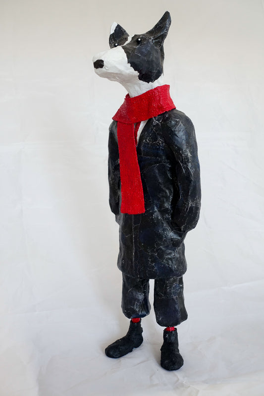 "Hund mit rotem Schal", angelehnt an den französischen Nachtclubbesitzer und Sänger Aristide Bruant im Pariser Montmartre, figurative Skulptur / Mensch-Tier-Hybridwesen aus Drahtgeflecht, Gipsbinden, bedrucktem Papier, Anzug mit schwarzer  Acrylfarbe, rote Socken, auf Eisenplatte