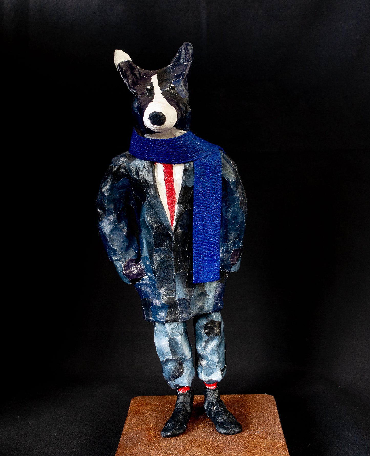 "Hund mit blauem Schal", figurative Skulptur / Mensch-Tier-Hybridwesen aus Drahtgeflecht, Gipsbinden, bedrucktem Papier und Acryl, rote Krawatte - auf Eisenplatte