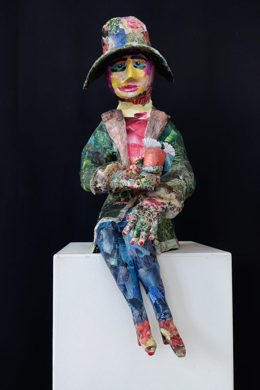 "Sitzende Frau mit bunter Kleidung", figurative Skulptur / frei nach einer Figur aus einem Gemälde von Edward Hopper, Augen im Stile von Alexej von Jawlensky,  aus Drahtgeflecht, Gipsbinden, bedrucktem Papier
